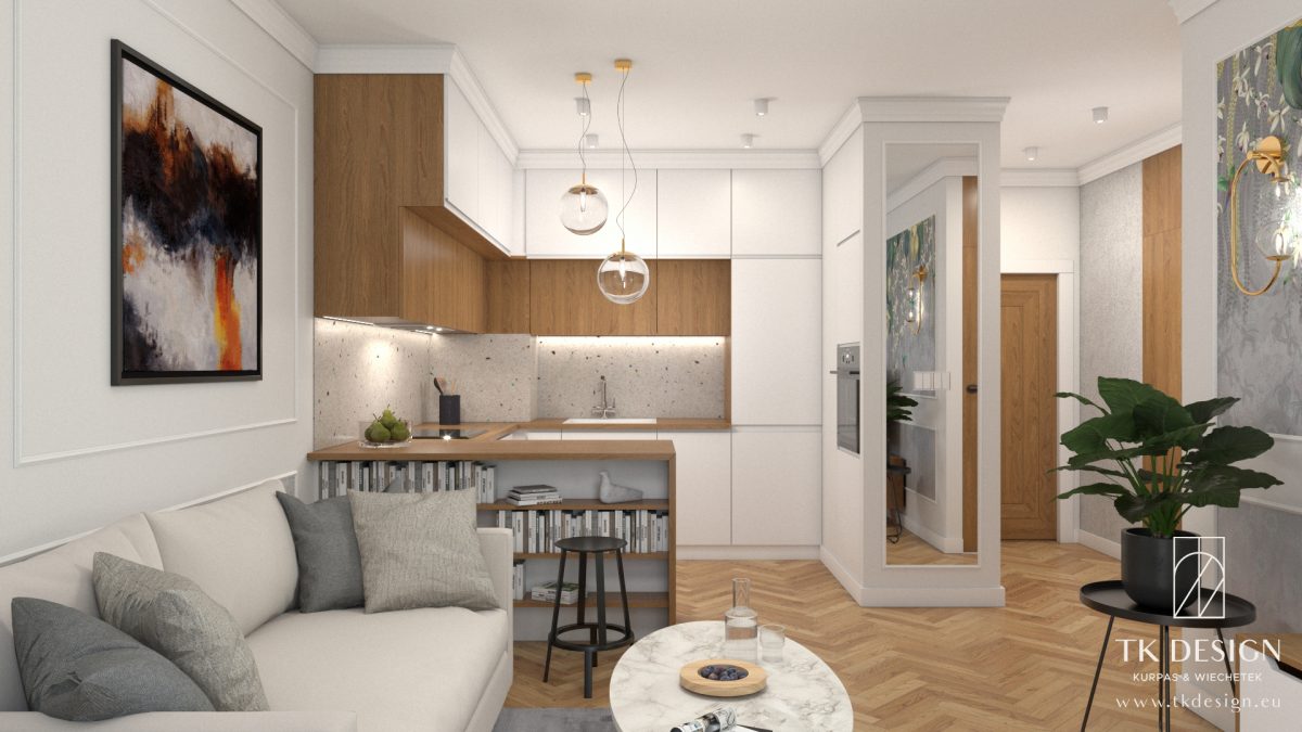 Strefa dzienna z aneksem kuchennym w jasnych ciepłych kolorach. Ściany w bardzo delikatnym odcieniu beżu są przełamane tynkiem strukturalnym o porowatej teksturze firmy Luxmal, a także uporządkowane przy użyciu sztukaterii ściennej firmy Mardom. Na podłodze została wykorzystana deska podłogowa Parkiet Studio ułożona w jodłę francuską. Kuchnia w bieli połączona z drewnopodobną płytą laminowaną firmy Egger. Całość uzupełniają lampy firmy Kaspa - szkło ze złotem - oraz tapeta Casamance.